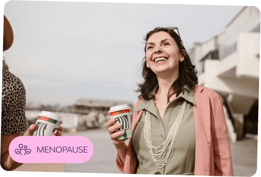 Smiling woman holding a coffee cup — representing confident support through menopause