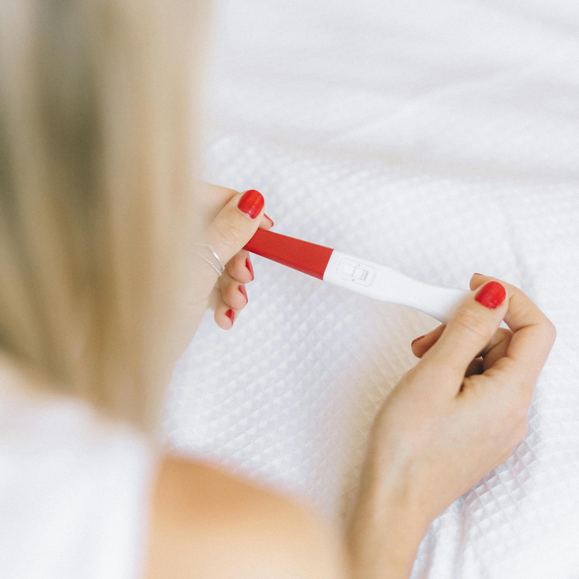 a woman looking at a pregnancy test